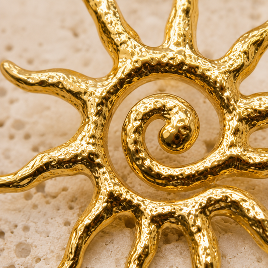 Gold Sun Statement Earrings pair styled on neutral stone and satin