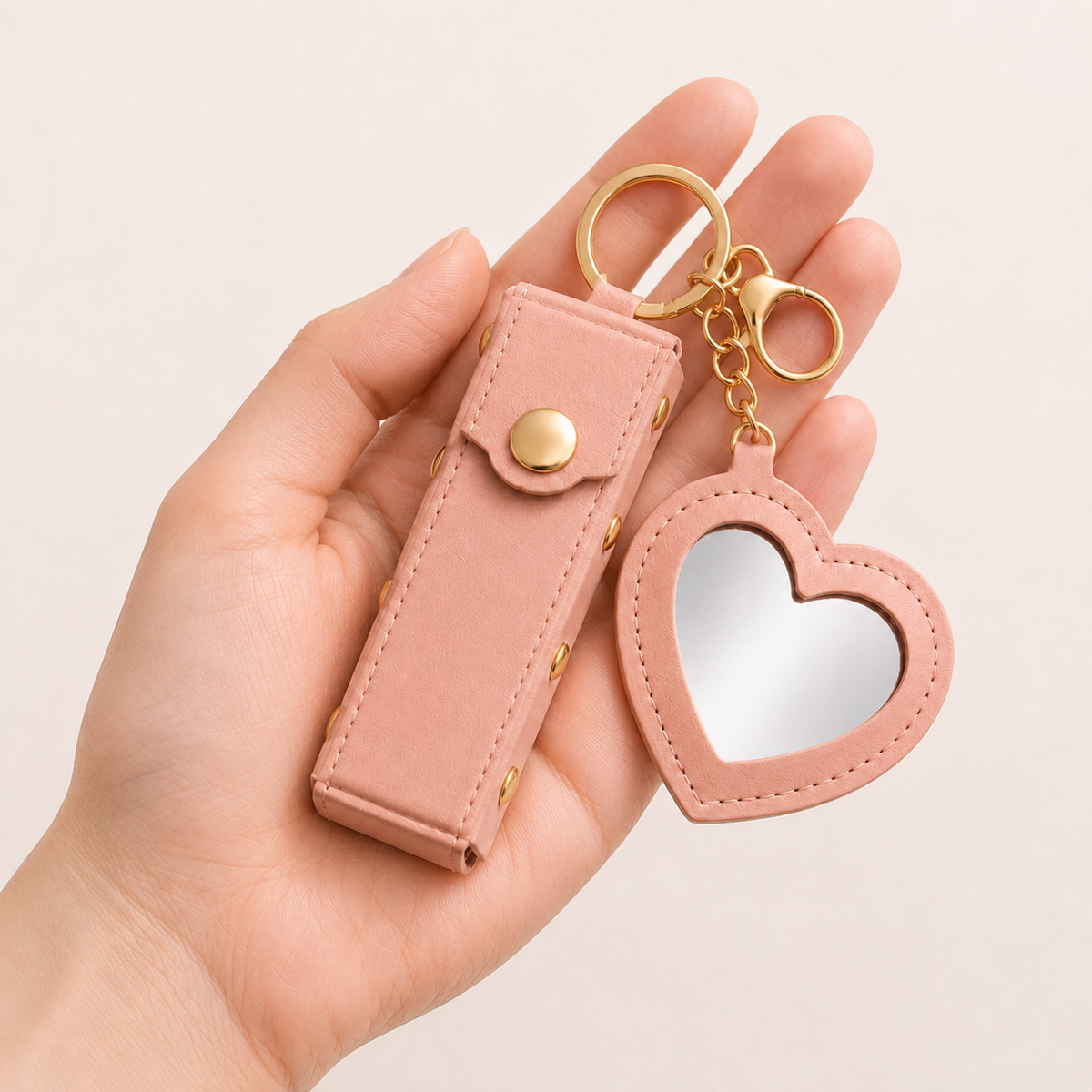 Pink Lipstick Holder and Mini Heart Mirror Keychain shown in hand for scale