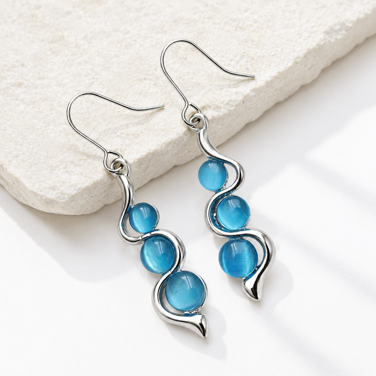 Alternate product view of Blue Wave Dangle Earrings on a pale stone surface