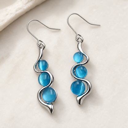 Blue Wave Dangle Earrings worn in a soft neutral lifestyle setting