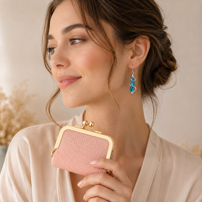 Model wearing Blue Wave Earrings while holding pink mini leather coin purse